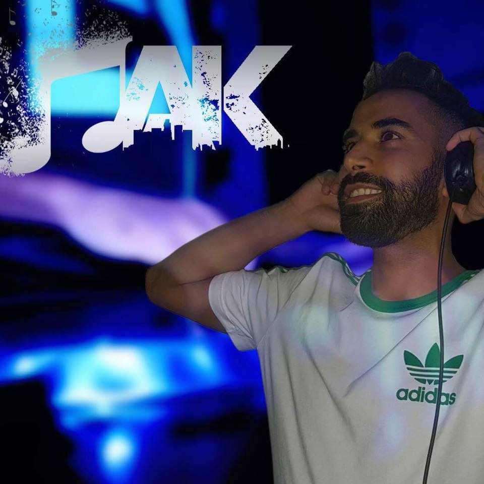 DJ MAK avec un casque et un grand sourire.