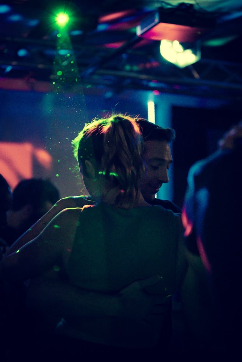 Deux danseurs sous des lumières de boite de nuit.