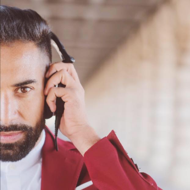 Une image de DJ MAL avec son casque et sa veste rouge.